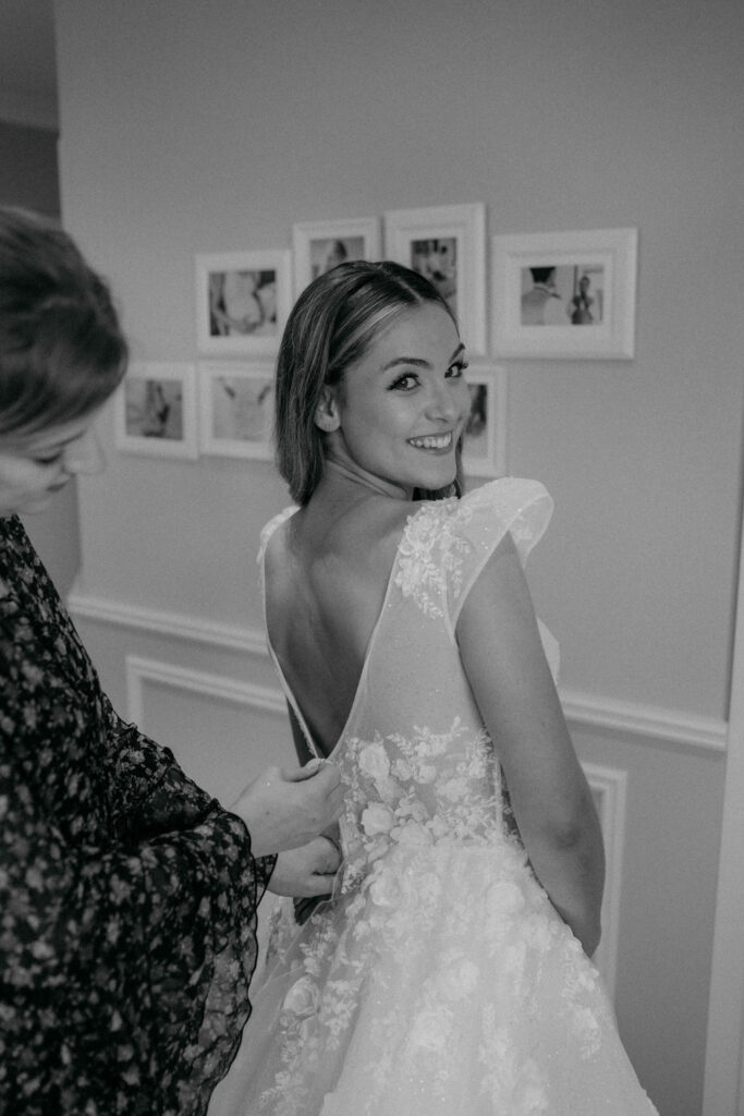 Braut lächelt im Hochzeitskleid vor der Trauung