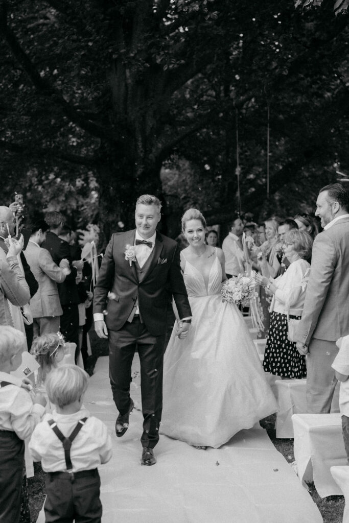 Hochzeitspaar verlässt die Zeremonie Hand in Hand