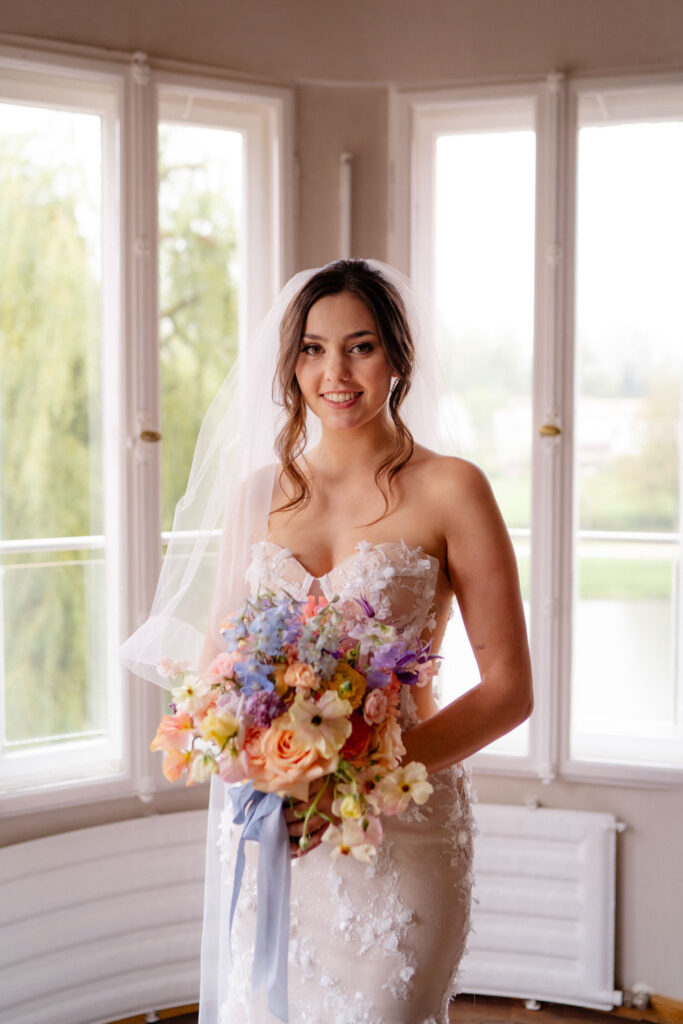 Braut in elegantem Hochzeitskleid hält Blumenstrauß
