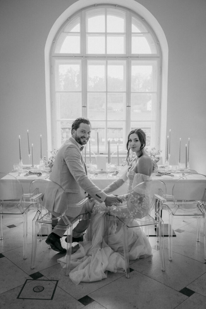 Brautpaar sitzt gemeinsam am Hochzeitstisch elegant