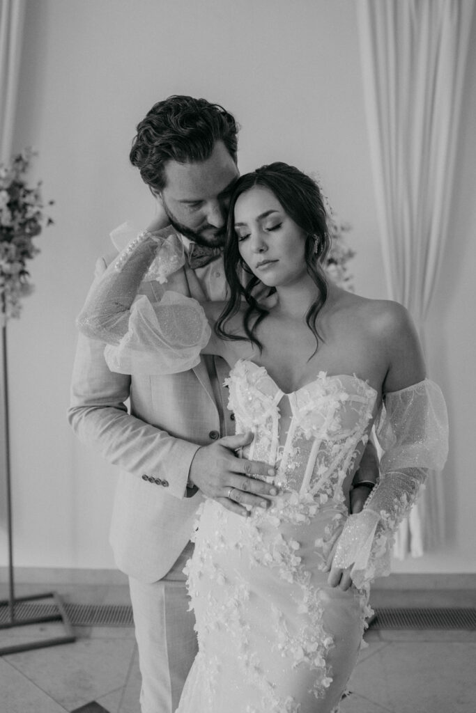Brautpaar umarmt sich liebevoll an der Hochzeit