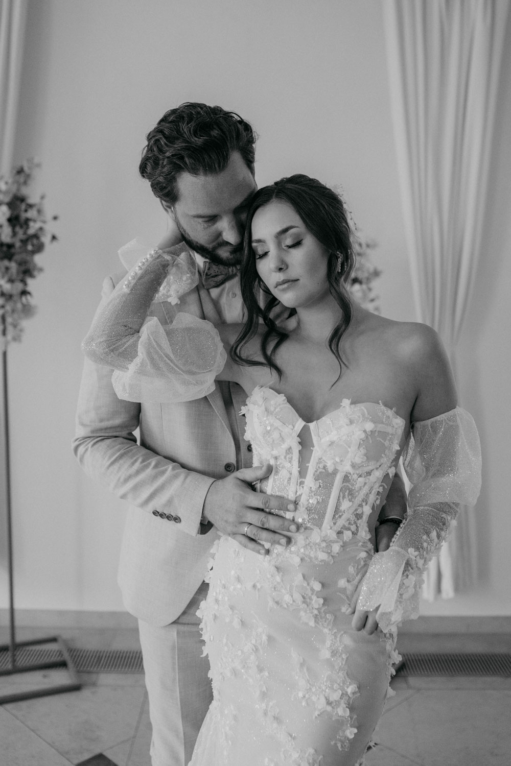 Brautpaar umarmt sich liebevoll an der Hochzeit