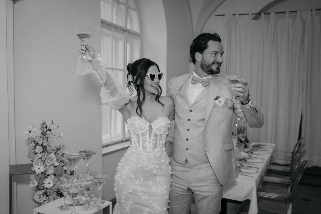 Brautpaar feiert Hochzeit mit Sektglas im Festsaal