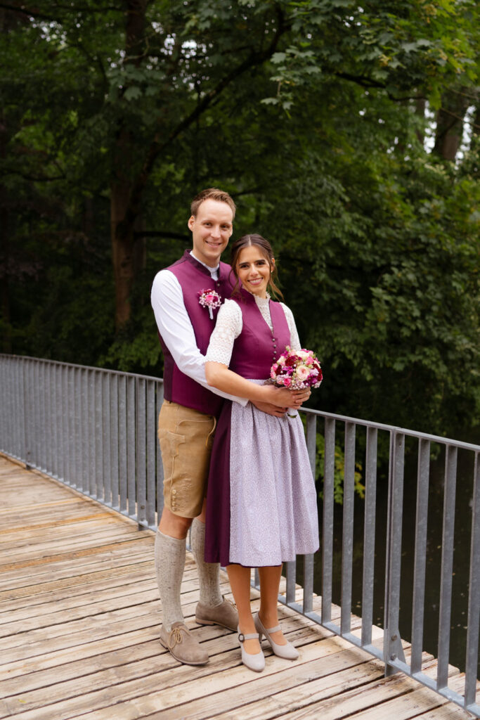 Paar in traditioneller Kleidung auf Holzbrücke posierend