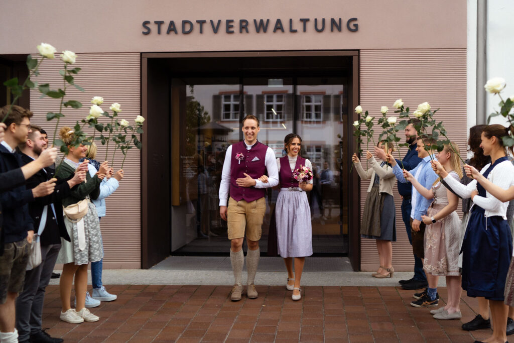 Paar verlässt das Standesamt mit Freunden Feier.