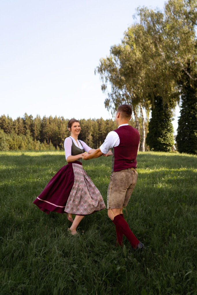 Paar tanzt in traditioneller Kleidung auf Wiese