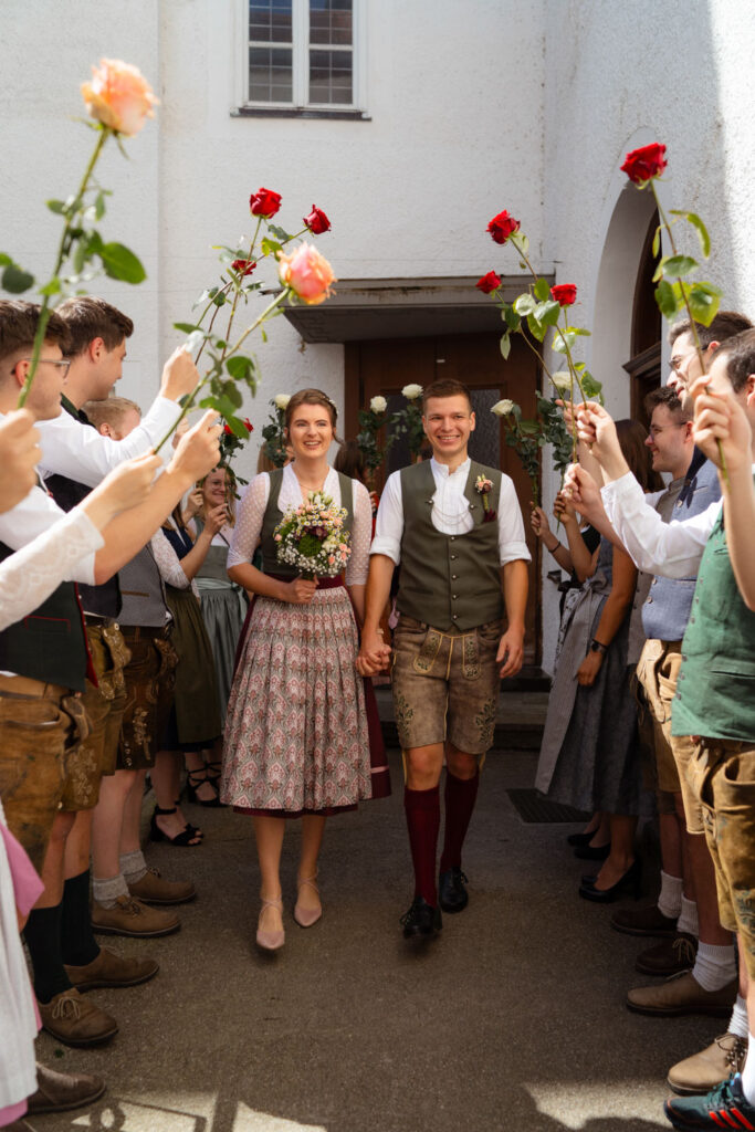 Traditionelle bayrische Hochzeit mit Rosen-Spalier draußen feiern