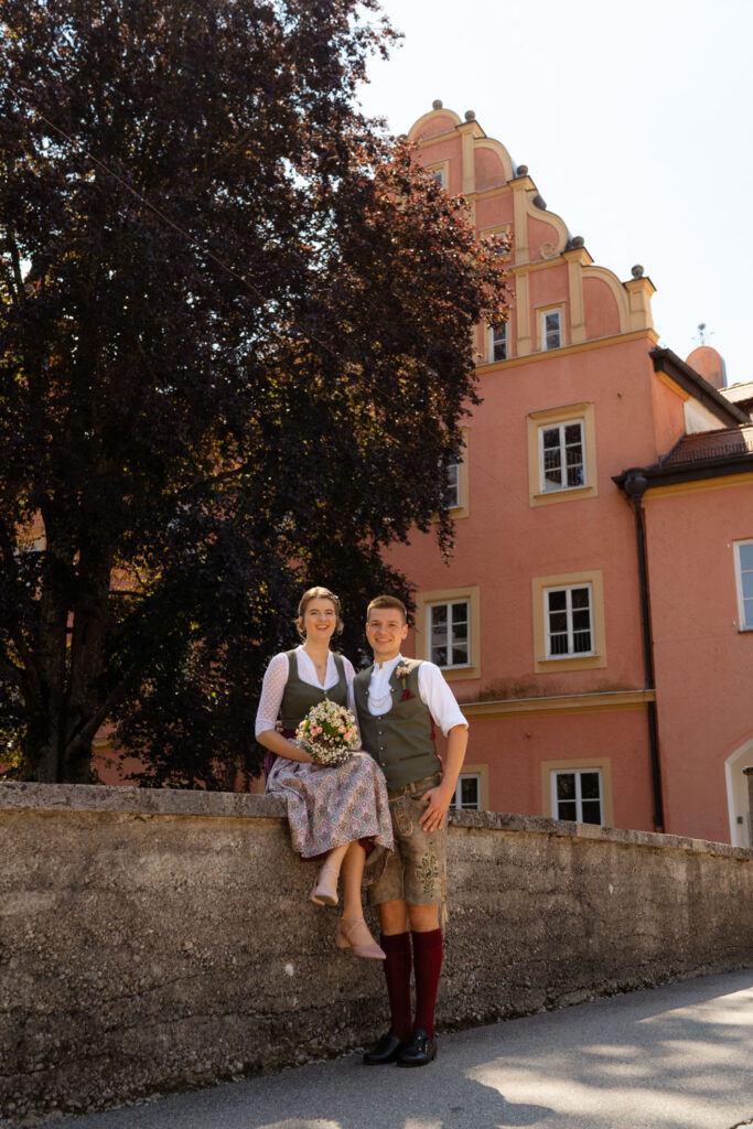 Paar in traditioneller Tracht vor historischem Gebäude