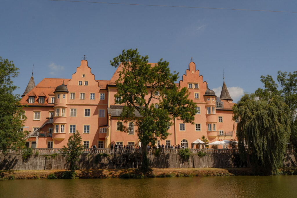 Großes historisches Gebäude mit Bäumen am Wasser