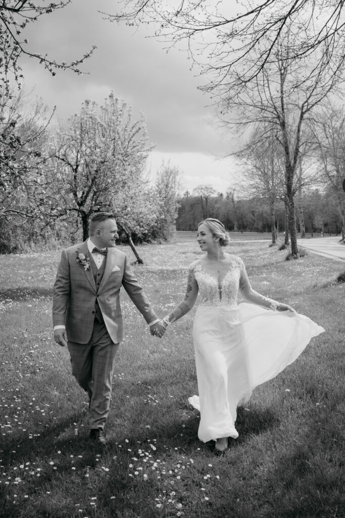 Hochzeitspaar spaziert durch blühenden Frühlingsgarten