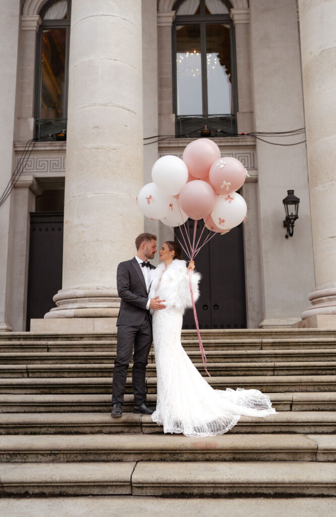 Elegantes Brautpaar mit Luftballons auf Treppe
