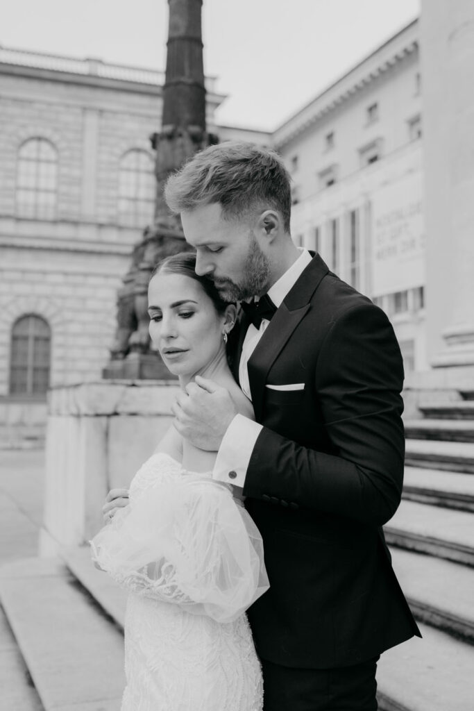 Elegant Hochzeitspaar posiert vor historischem Gebäude