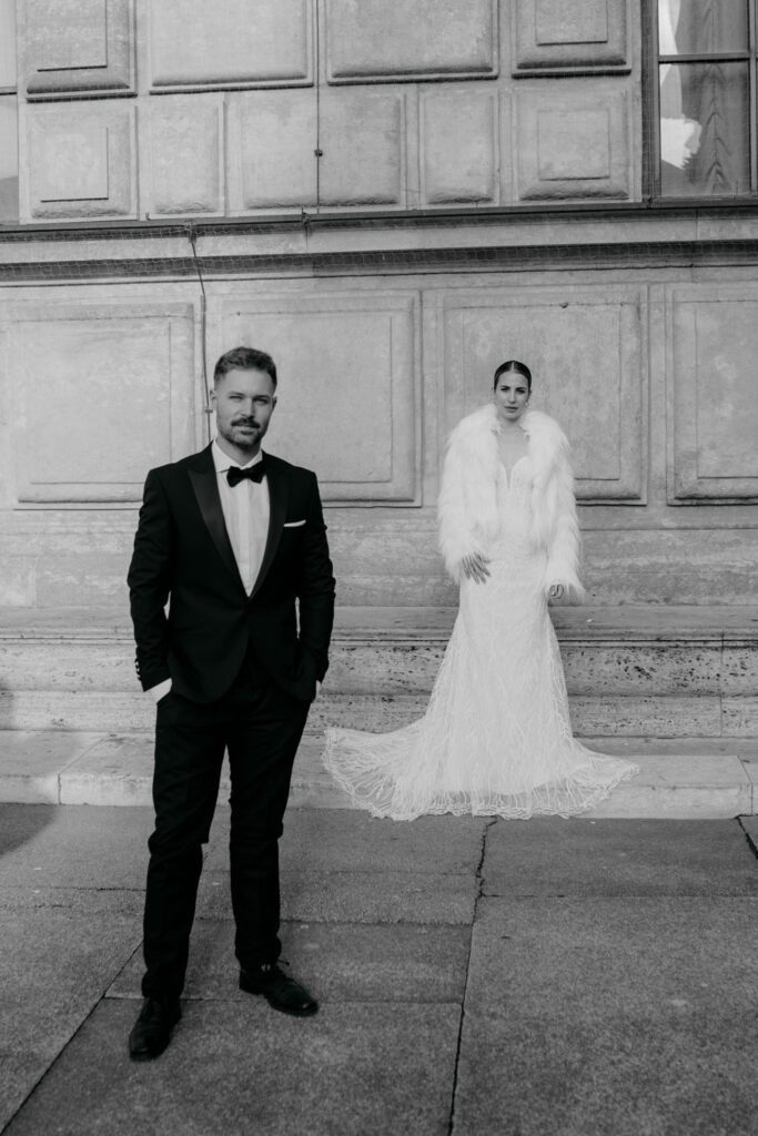 Elegantes Brautpaar in formeller Hochzeitskleidung posiert draußen