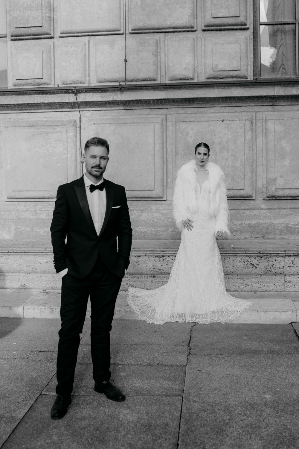 Elegantes Brautpaar in formeller Hochzeitskleidung posiert draußen