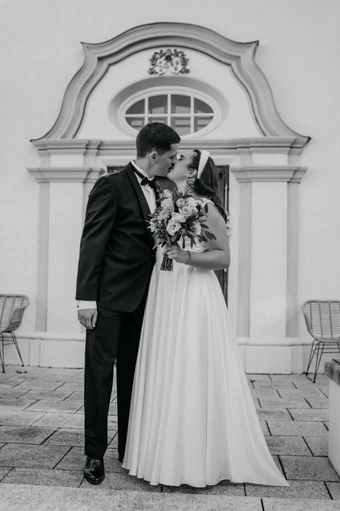 Brautpaar beim Hochzeitskuss vor historischer Kulisse